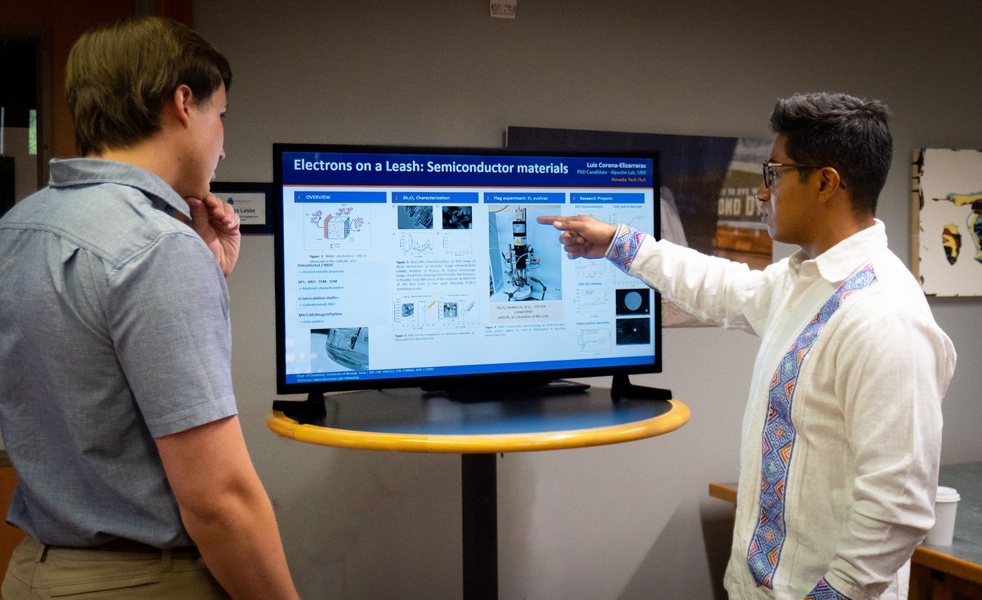 A student demonstrates analytical software on a large screen during the lab open house